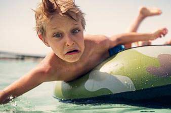 Kid falling off an inner tube into the water