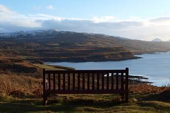 Bench seat overlooking a view of hills and a lake