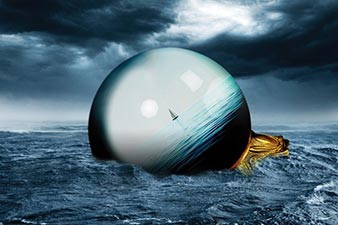 Crystal ball - showing a becalmed yacht - floating in a stormy sea