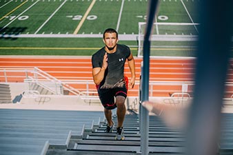 Althlete training by running up stadium stairs