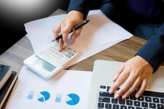 Person working with a calculator and laptop