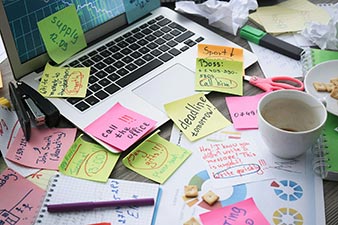 Laptop covered in sticky note reminders