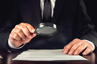 Closely examining a report using a magnifying glass